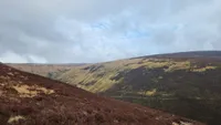 A brown slope in the foreground, with a steep, flat-topped hill beyond. headwaters of Allt Scheicheachan